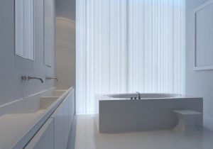 bathroom with dual sinks, a tub, and sheer curtains