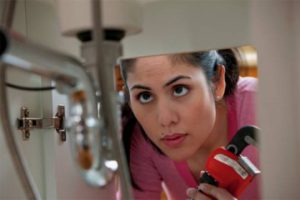 Woman looking at sink drain to fix